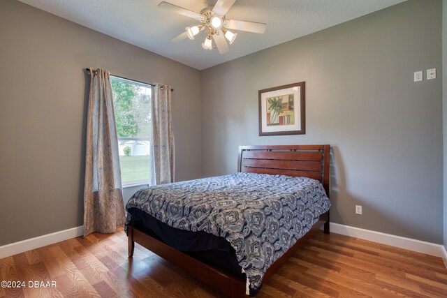 bedroom featuring a textured ceiling, hardwood / wood-style floors, and ceiling fan