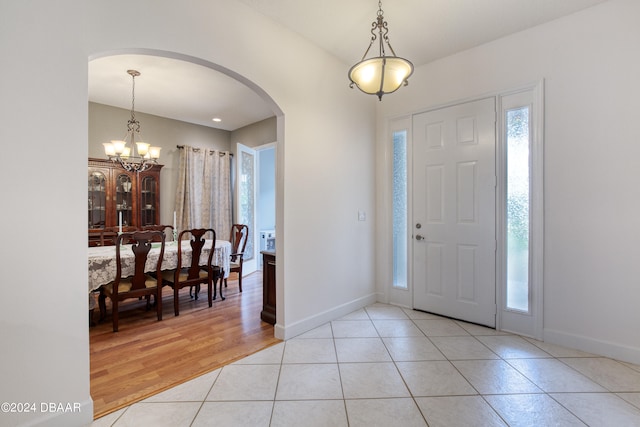 foyer with light hardwood / wood-style flooring and an inviting chandelier