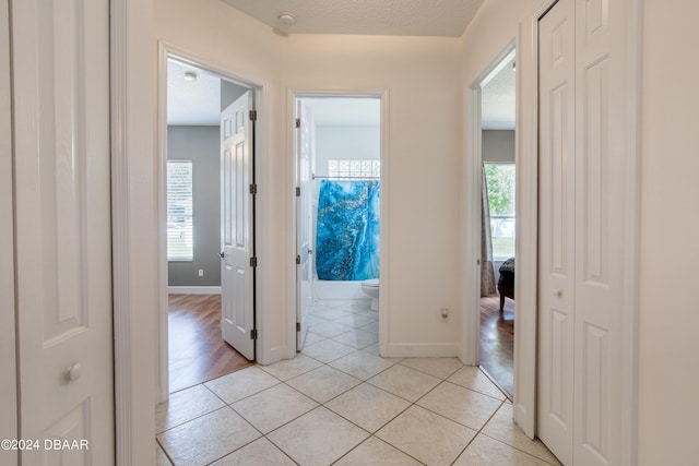 hallway featuring a textured ceiling and light hardwood / wood-style flooring