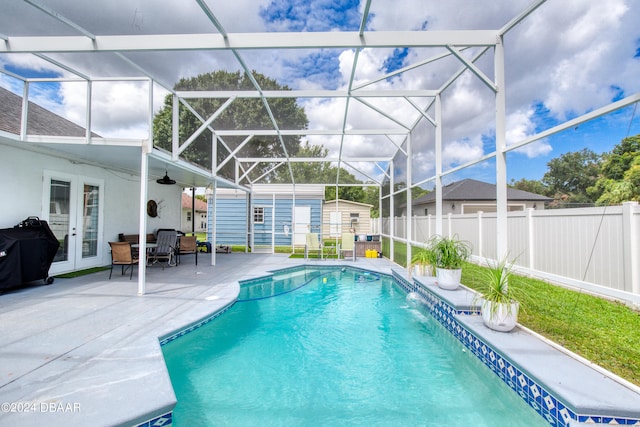 view of pool featuring a shed, ceiling fan, a patio, a lanai, and pool water feature