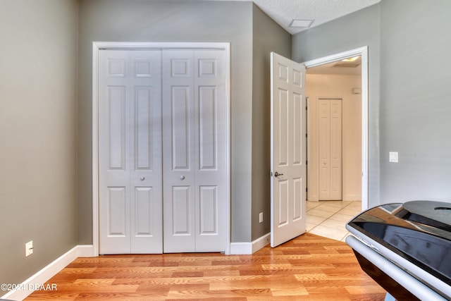 interior space featuring a closet, light wood-type flooring, and a textured ceiling