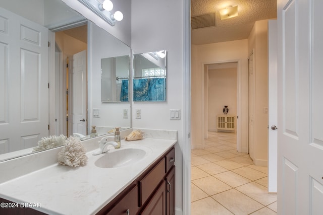 bathroom with vanity, tile patterned flooring, and a textured ceiling