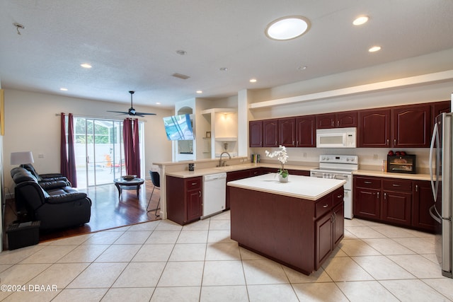 kitchen with kitchen peninsula, sink, ceiling fan, light tile patterned flooring, and white appliances