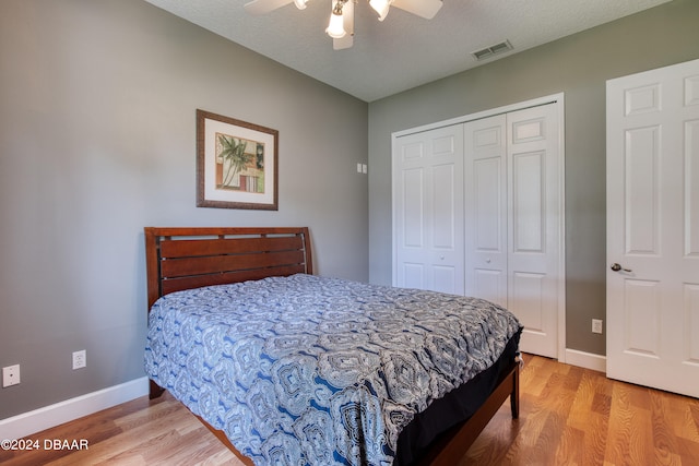 bedroom featuring hardwood / wood-style floors, ceiling fan, a textured ceiling, and a closet