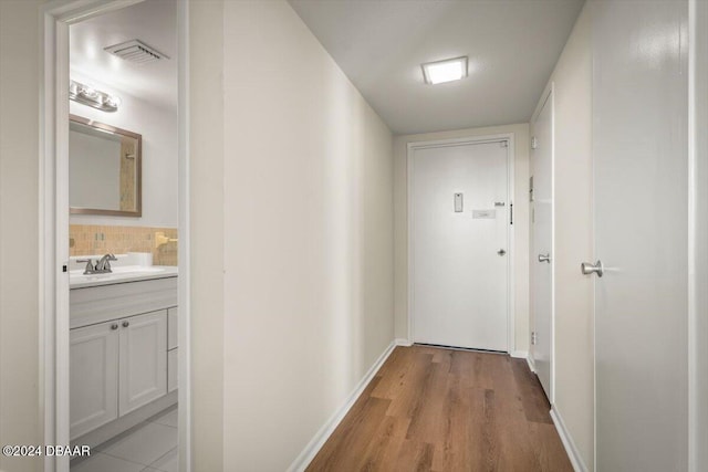 corridor featuring light hardwood / wood-style flooring and sink