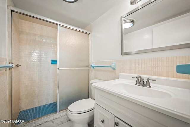 bathroom featuring an enclosed shower, vanity, toilet, and tile walls