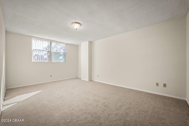 carpeted spare room with a textured ceiling