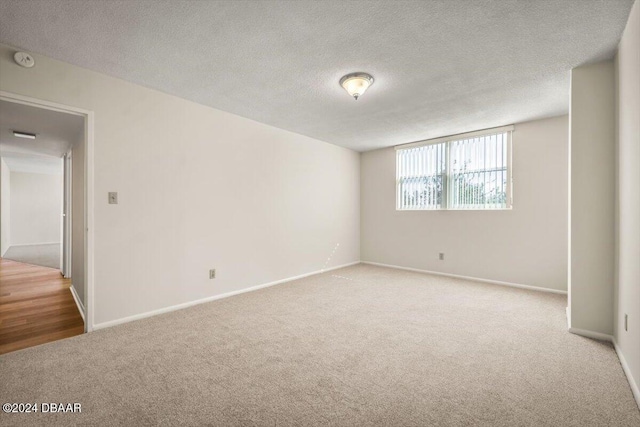 carpeted spare room with a textured ceiling