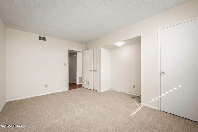 unfurnished bedroom featuring carpet floors and a textured ceiling