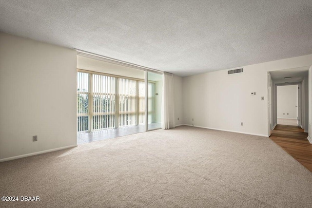 empty room featuring carpet and a textured ceiling