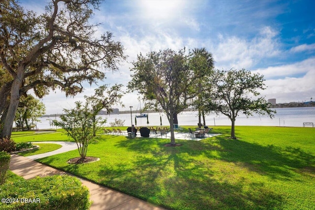 view of property's community featuring a lawn and a water view