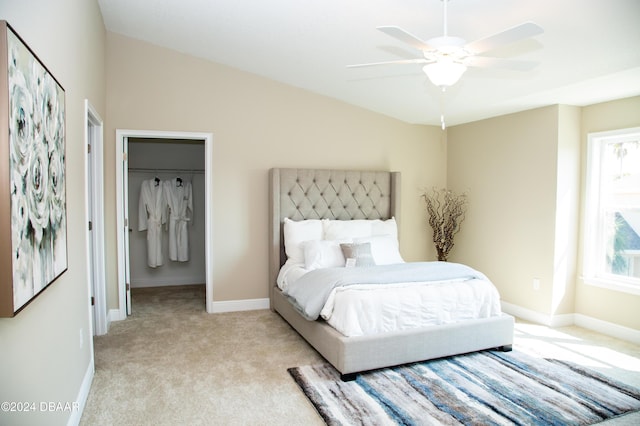 bedroom featuring a walk in closet, vaulted ceiling, light colored carpet, and baseboards