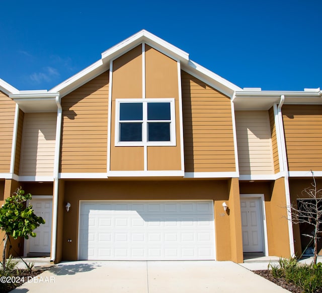 townhome / multi-family property with stucco siding, concrete driveway, and an attached garage