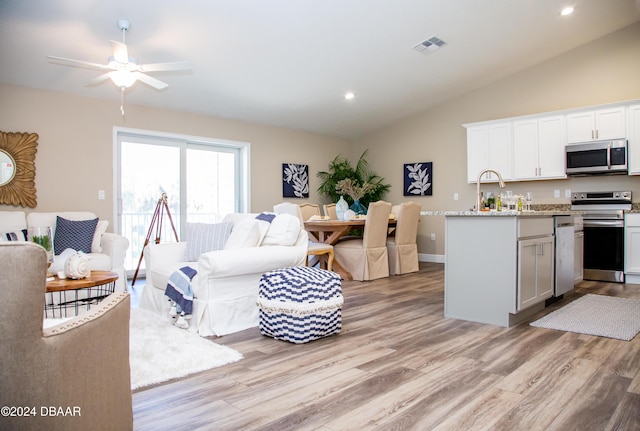 kitchen with visible vents, light wood-type flooring, vaulted ceiling, appliances with stainless steel finishes, and open floor plan