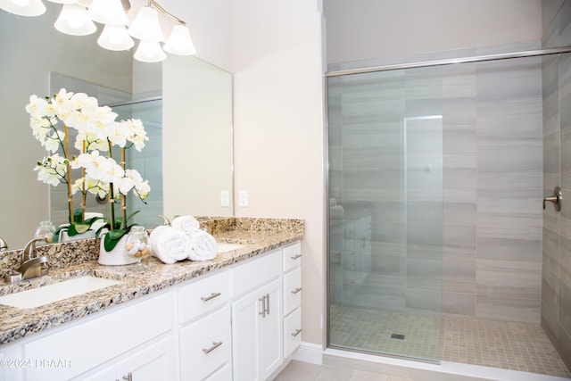 bathroom with a shower stall, double vanity, and a sink