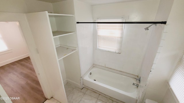 bathroom with tile patterned flooring and bathing tub / shower combination