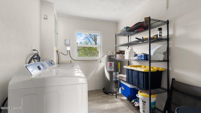 laundry area with washer and dryer, laundry area, wood finished floors, and electric water heater