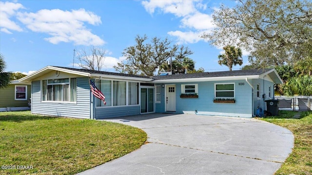 ranch-style home featuring a front yard and concrete driveway