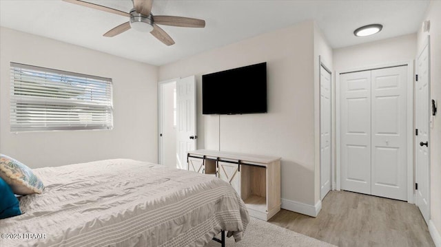 bedroom with a closet, baseboards, light wood-style flooring, and a ceiling fan