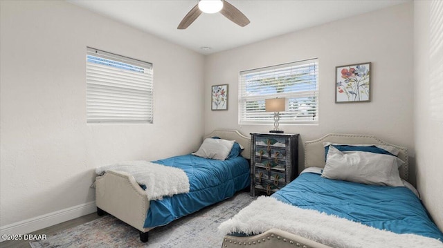 bedroom featuring baseboards, wood finished floors, and a ceiling fan