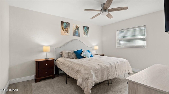 bedroom with ceiling fan, baseboards, and wood finished floors