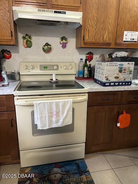 kitchen featuring light tile patterned floors and white electric range