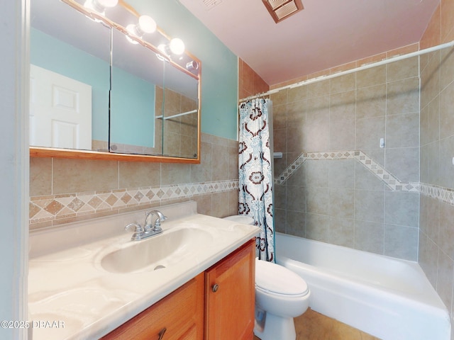 2101 N Atlantic Ave Unit 24, Daytona Beach, FL 32118 - bathroom featuring toilet, tile walls, vanity, visible vents, and shower / tub combo