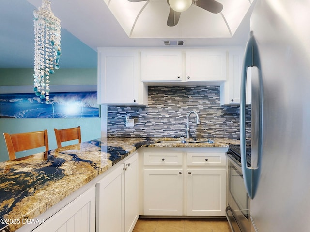 2101 N Atlantic Ave Unit 24, Daytona Beach, FL 32118 - kitchen with a ceiling fan, a sink, white cabinetry, appliances with stainless steel finishes, and tasteful backsplash