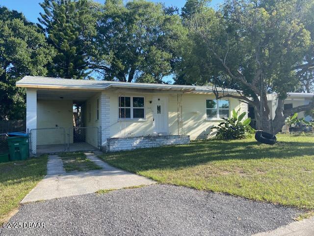 264 Sherwood Ln, Holly Hill, FL 32117 - view of front of home with dirt driveway, a front yard, and an attached carport