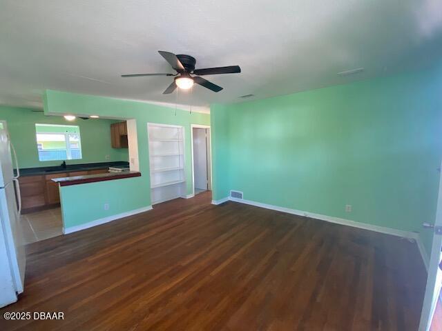 264 Sherwood Ln, Holly Hill, FL 32117 - unfurnished living room featuring wood finished floors and a ceiling fan