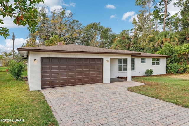 ranch-style house with a garage and a front lawn