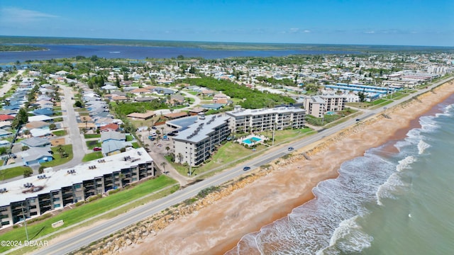 birds eye view of property featuring a beach view and a water view