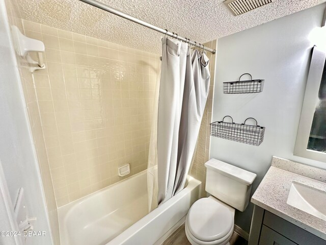 full bathroom with vanity, shower / bath combo with shower curtain, and toilet