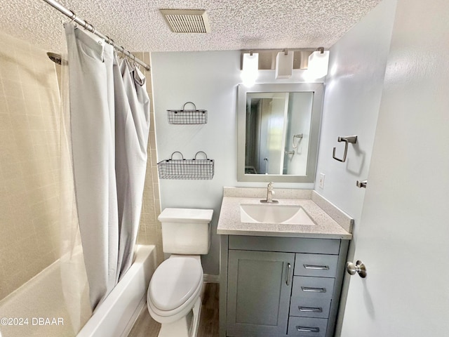 full bathroom featuring a textured ceiling, hardwood / wood-style floors, shower / tub combo with curtain, vanity, and toilet