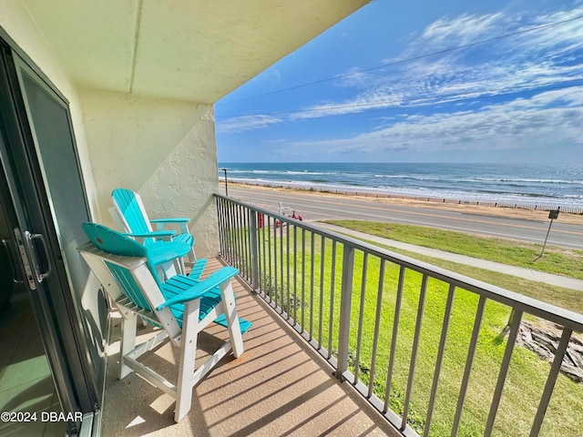 balcony featuring a view of the beach and a water view