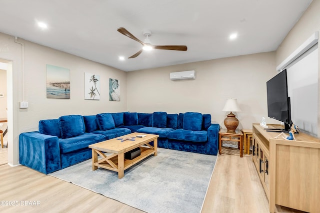 living room with light hardwood / wood-style flooring, a wall unit AC, and ceiling fan