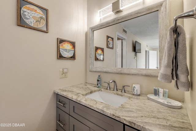 bathroom with a textured ceiling and vanity