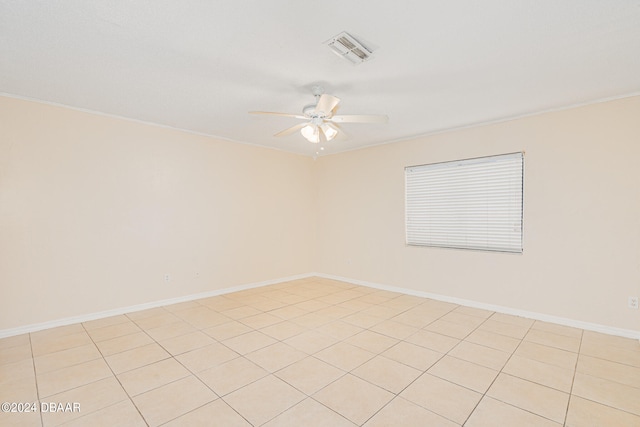 tiled spare room with ornamental molding and ceiling fan