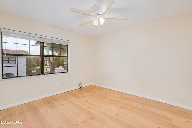 spare room with ceiling fan and light wood-type flooring