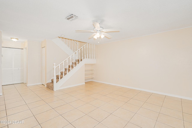 tiled spare room featuring ceiling fan