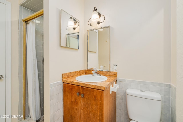 bathroom featuring walk in shower, vanity, toilet, and tile walls