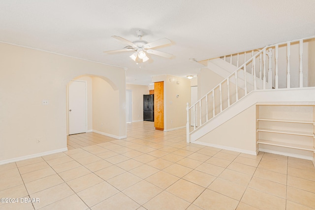 tiled spare room featuring ceiling fan