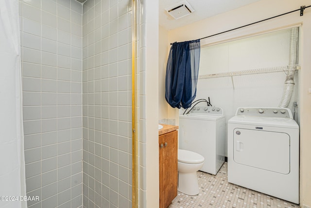 bathroom with vanity, tile patterned floors, toilet, and independent washer and dryer