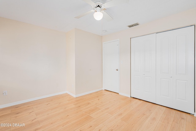 unfurnished bedroom featuring a closet, hardwood / wood-style floors, and ceiling fan