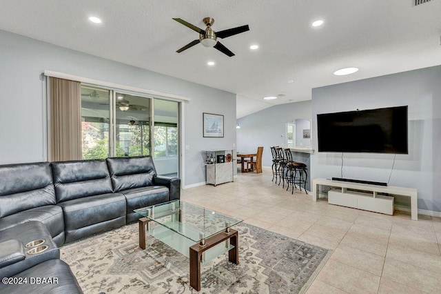 tiled living room with ceiling fan and vaulted ceiling