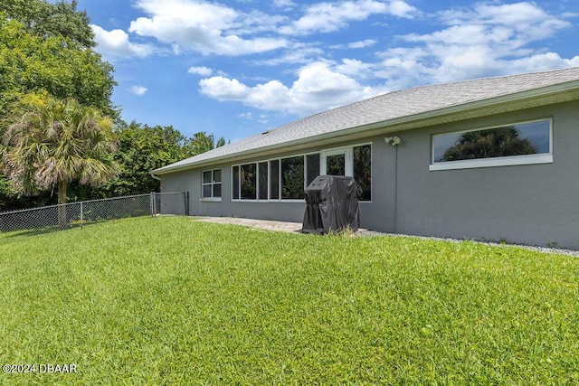 rear view of house featuring a yard