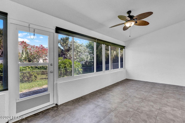 unfurnished sunroom featuring ceiling fan and plenty of natural light