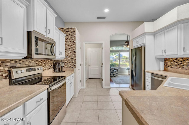 kitchen featuring light tile patterned floors, stainless steel appliances, white cabinets, and ceiling fan