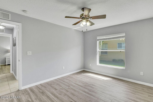 empty room with ceiling fan, a textured ceiling, and light hardwood / wood-style floors