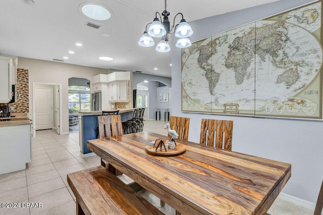 dining space with light tile patterned floors and a chandelier